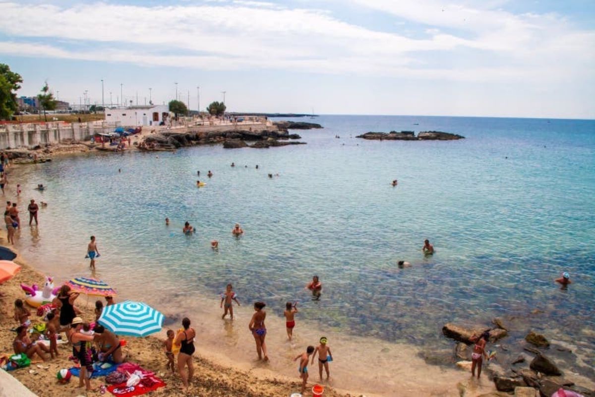 Spiaggia di Porta Vecchia al tramonto con persone che si godono il panorama