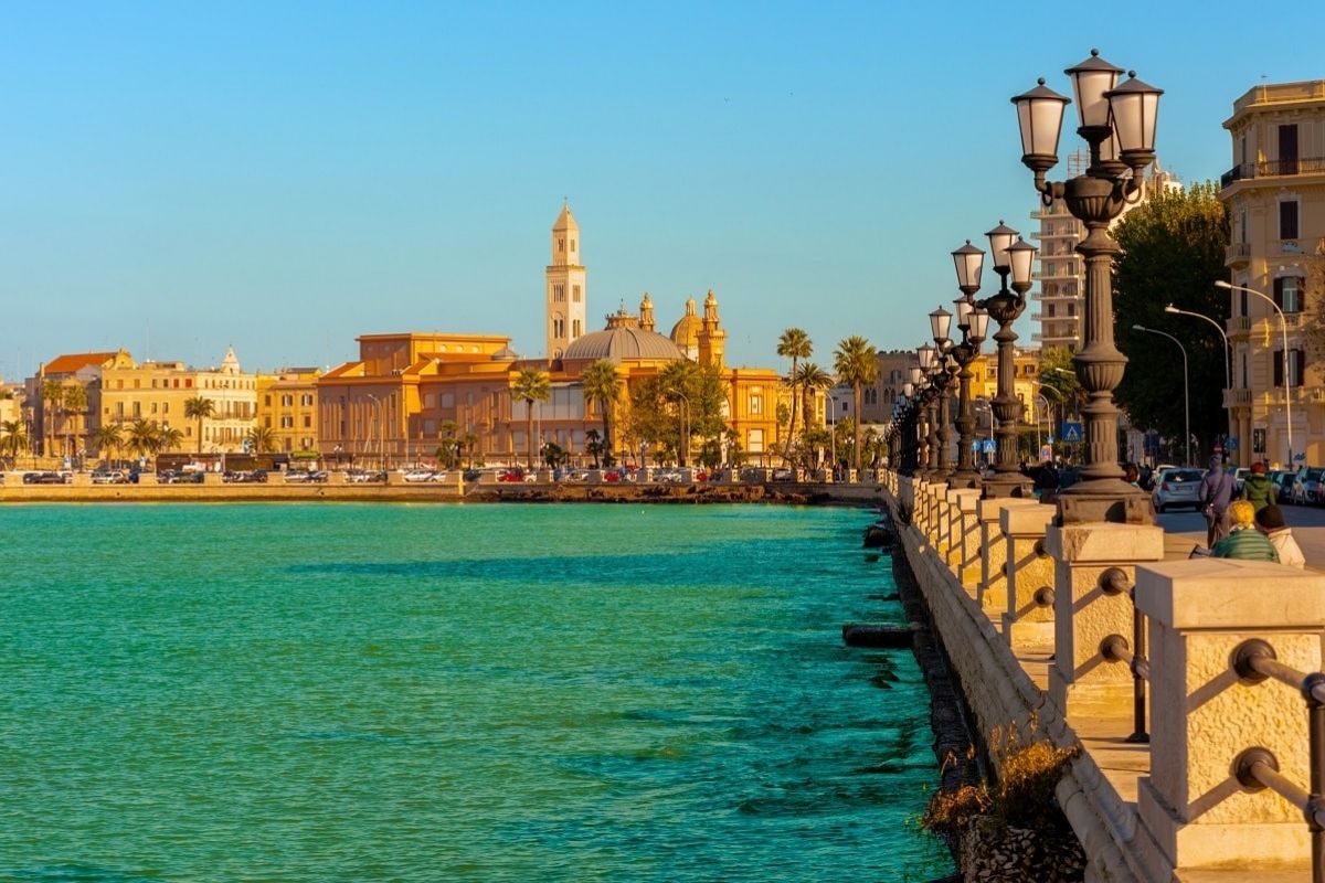 Vista panoramica del lungomare di Bari al tramonto con persone che passeggiano